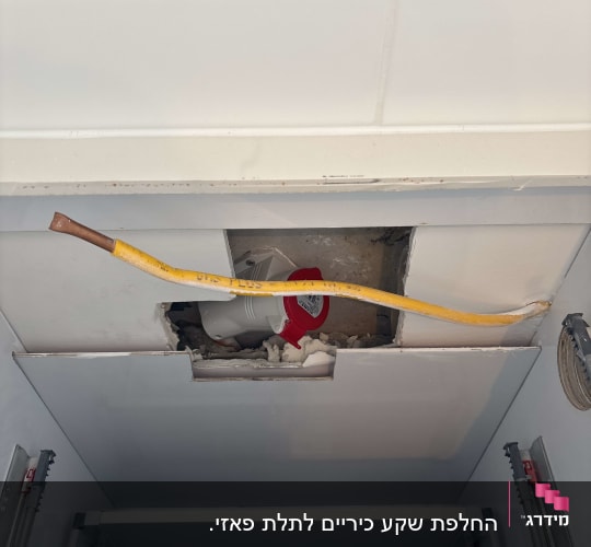 חוט חשמל צהוב יוצא מתקרה עם חור